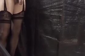 A man in cross-dressing being whipped by a large electr